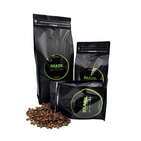 Three black coffee bags of varying sizes, surrounded by scattered coffee beans. Three black coffee bags of varying sizes, surrounded by scattered coffee beans.