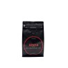 A sleek black coffee bag with bold red and white text, featuring earthy flavor notes. A sleek black coffee bag with bold red and white text, featuring earthy flavor notes.