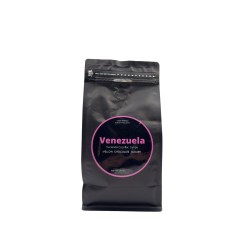 A sleek black bag of coffee with a vibrant pink label featuring the word "Venezuela."
