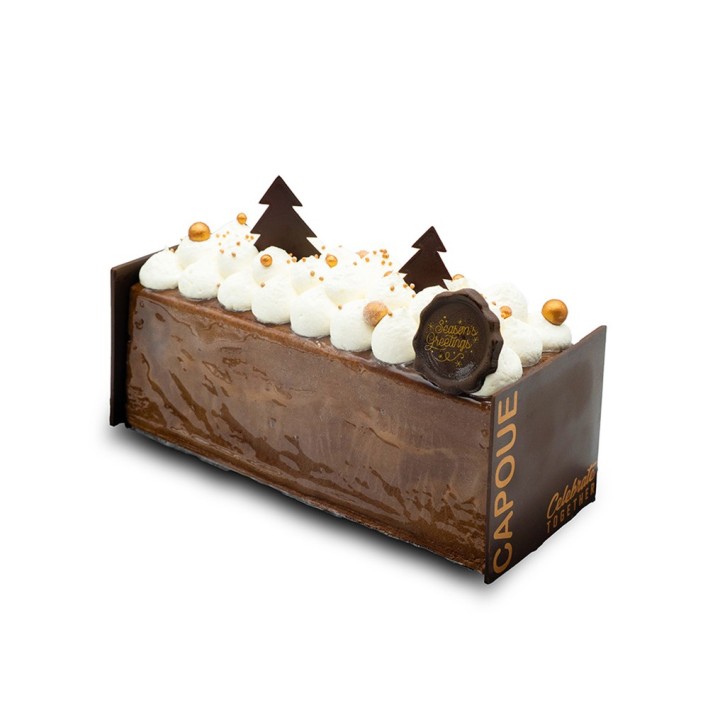 Een chocoladecake met witte room, gouden decoraties en kerstboompjes van chocolade.