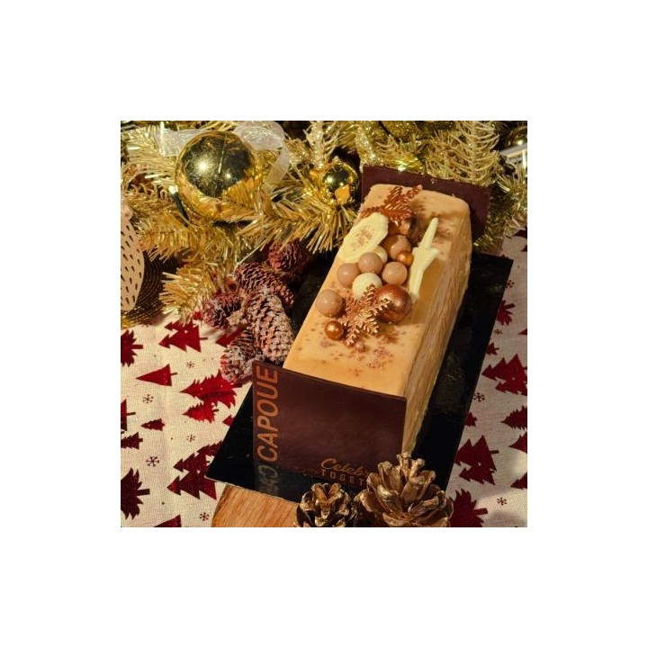 A festive cake adorned with golden ornaments and autumn leaves, surrounded by holiday decor.