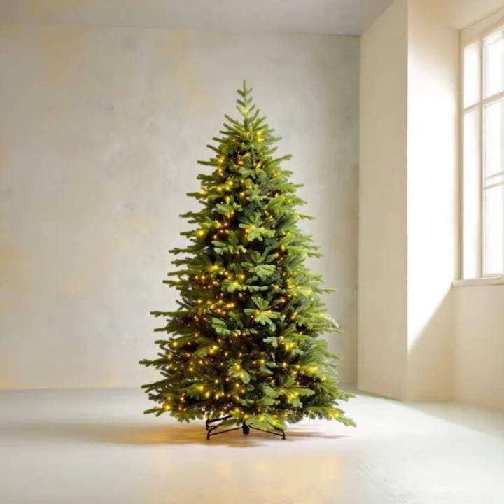 Un sapin vert illuminé de guirlandes, dans une pièce claire et minimaliste.